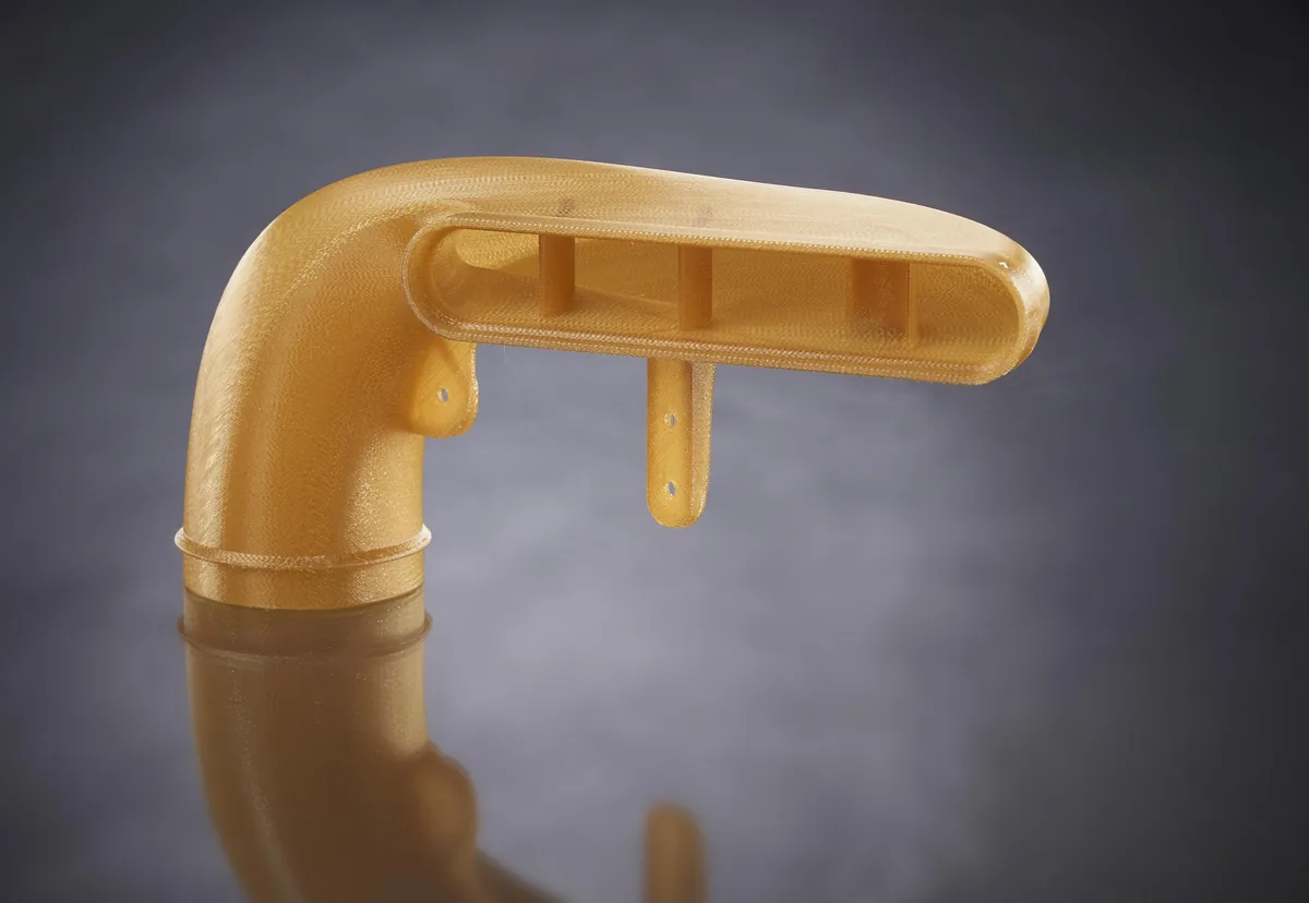 Fabricación aditiva con Ultem 1010: cuando la impresión 3D tiene que ir más allá del prototipo Conducto de toma de aire impreso en ULTEM 1010 mediante FDM, pieza aeronáutica de alta temperatura con geometría compleja y brida de fijación